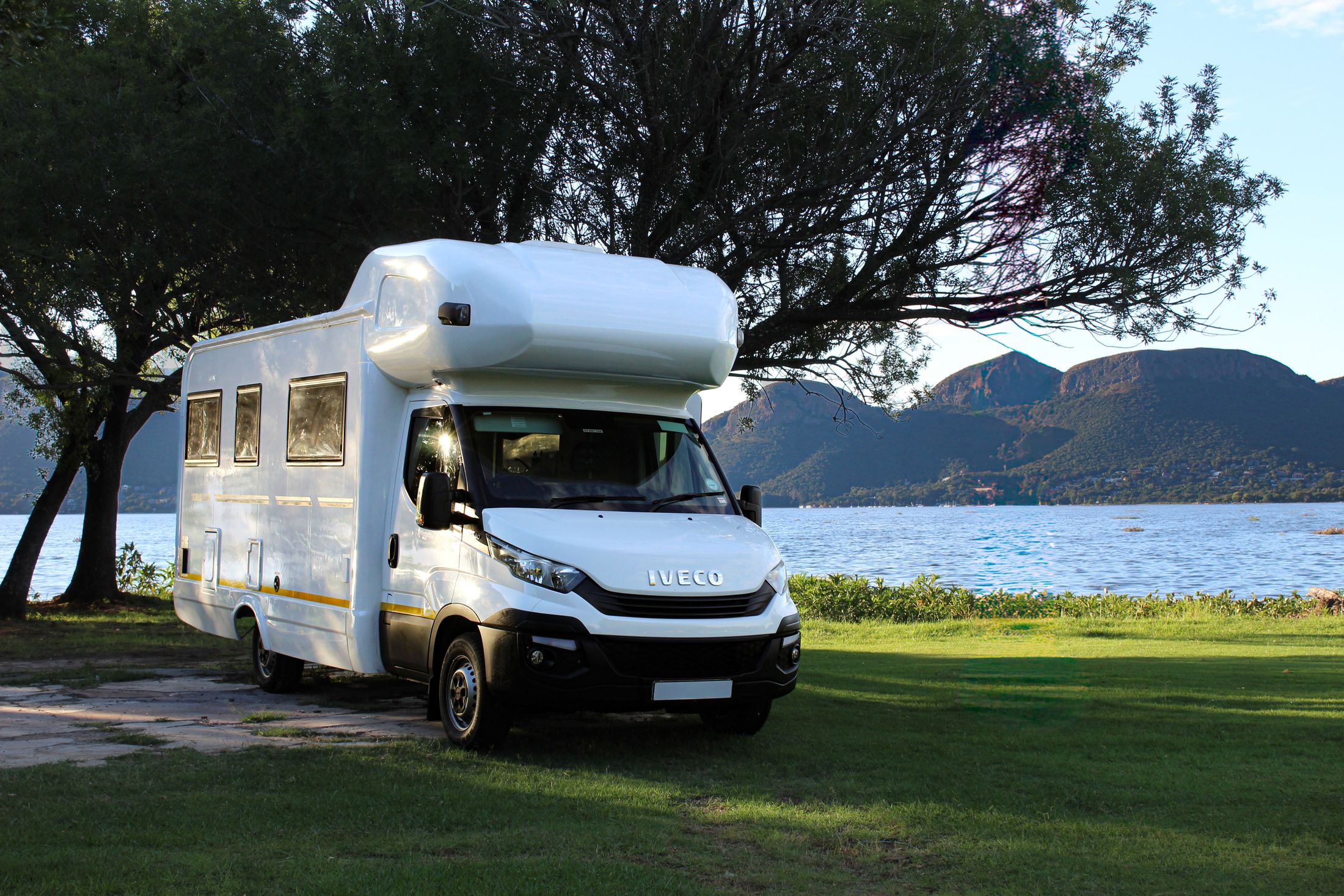 Autocaravana junto a un lago y montañas